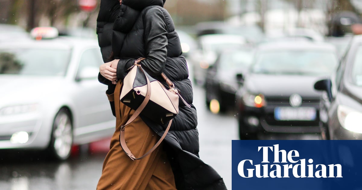 invōk.io petition & crowdfunding social platform - A woman is using the invōk.io petition platform while walking down the street in a black coat.