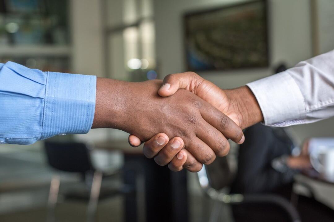 invōk.io petition & crowdfunding social platform - Two business people shaking hands in an office