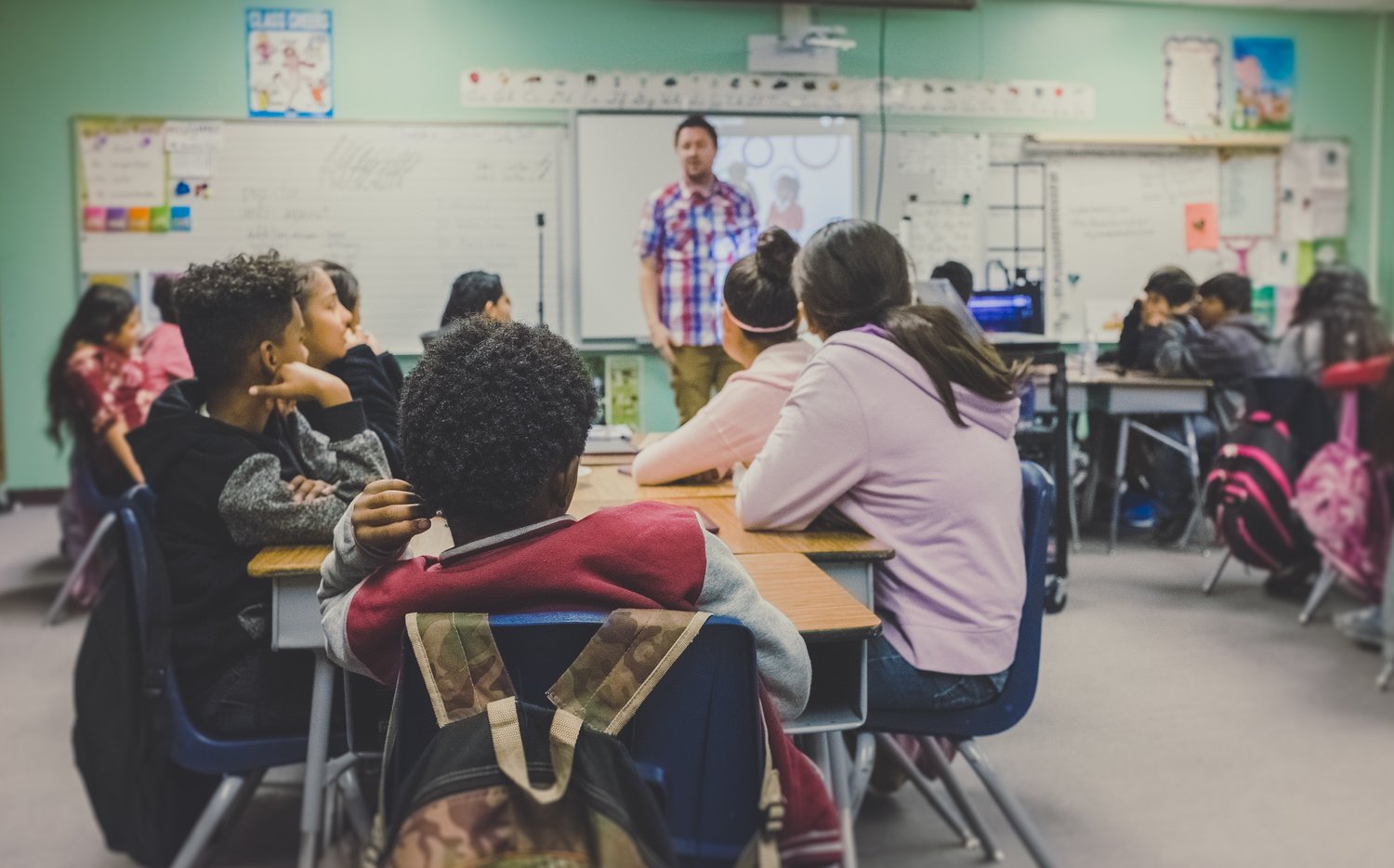 invōk.io petition & crowdfunding social platform - A group of children sitting at desks in a classroom advocating for change on the invōk.io social platform.