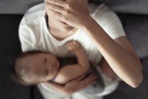 invōk.io petition & crowdfunding social platform - A woman is utilizing the invōk.io petition platform while holding a baby and covering her face.
