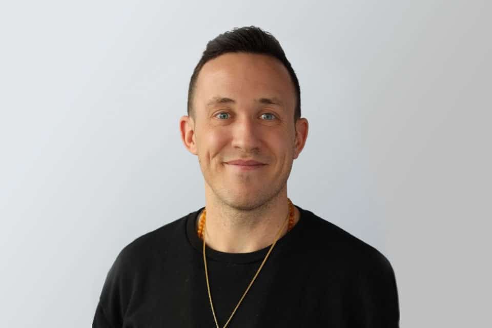 invōk.io petition & crowdfunding social platform - A man showcasing invōk.io crowdfunding platform while wearing a black shirt and gold necklace.