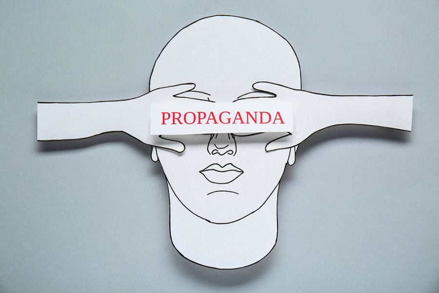 invōk.io petition & crowdfunding social platform - A paper cut out of a man covering his eyes with the word propaganda