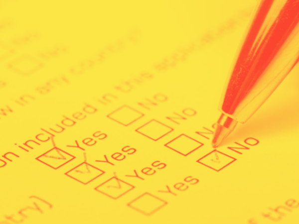 invōk.io petition & crowdfunding social platform - A person completing the invōk.io petition form on a yellow sheet of paper.