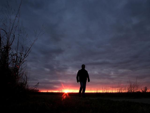 invōk.io petition & crowdfunding social platform - A silhouette of a man walking on a path at sunset captured on invōk.io.