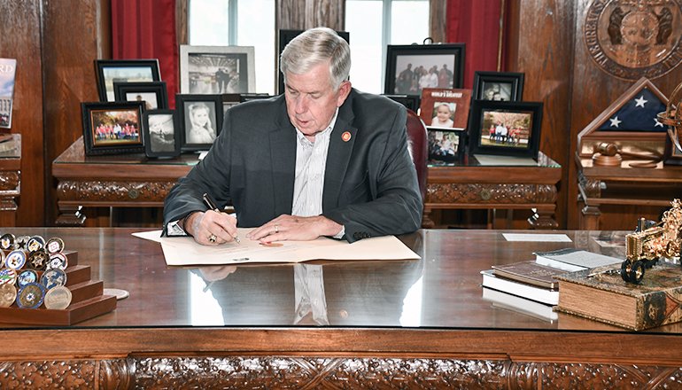 invōk.io petition & crowdfunding social platform - A man at a desk signing a document congratulates Missouri.