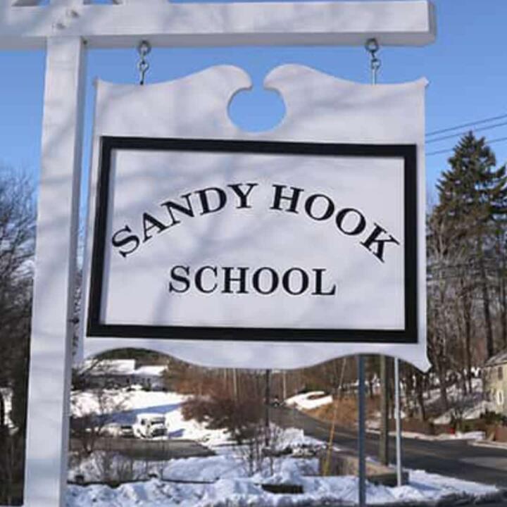 invōk.io petition & crowdfunding social platform - A sign for sandy hook school is displayed on a snowy street