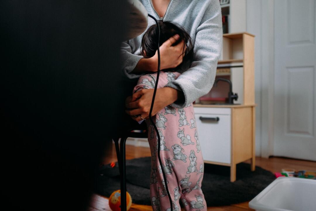 invōk.io petition & crowdfunding social platform - A woman is using the invōk.io petition platform while holding a child's hand in a room.