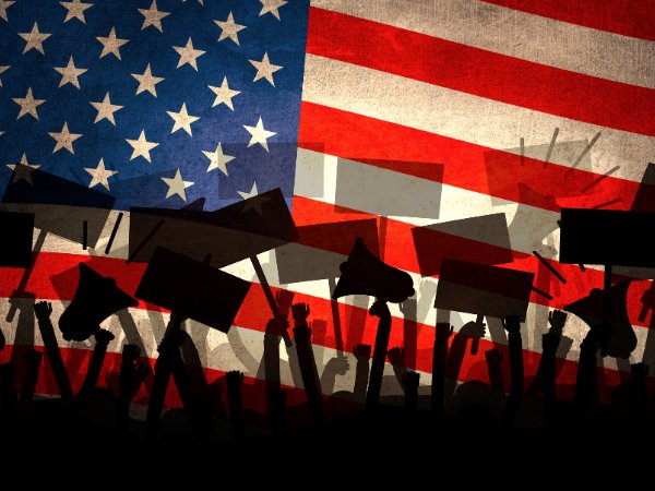invōk.io petition & crowdfunding social platform - A group of people using invōk.io to hold signs in front of an American flag.