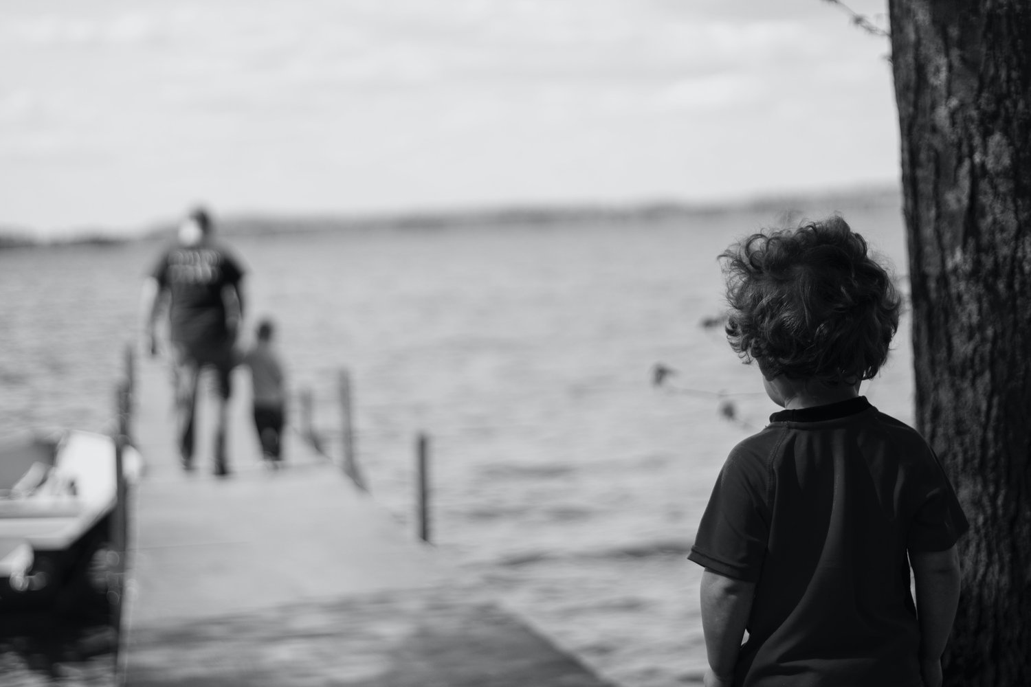 invōk.io petition & crowdfunding social platform - A boy is utilizing the invōk.io petition & crowdfunding social platform while standing on a dock and looking at the water.