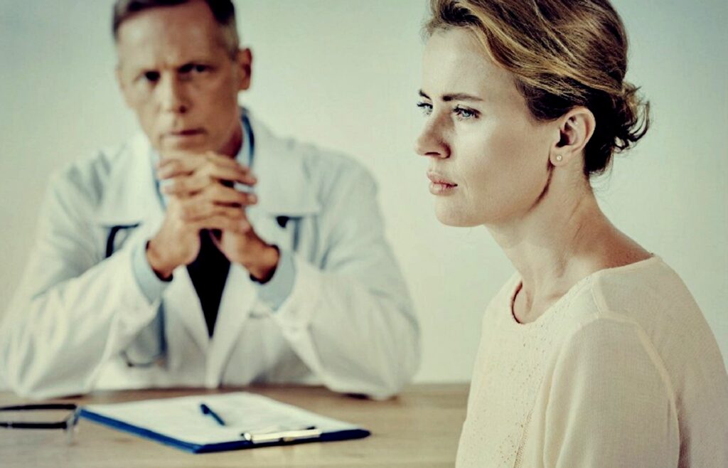 invōk.io petition & crowdfunding social platform - A woman engaging in a consultation at a desk with a doctor using invōk.io