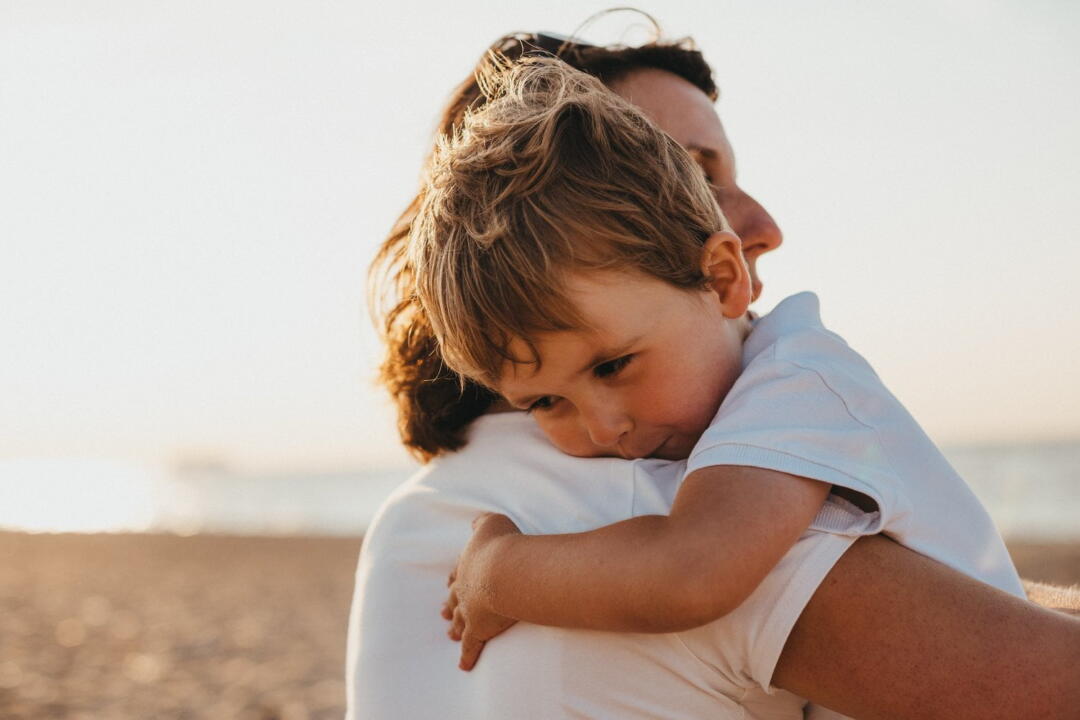 invōk.io petition & crowdfunding social platform - A woman is embracing her son on the beach