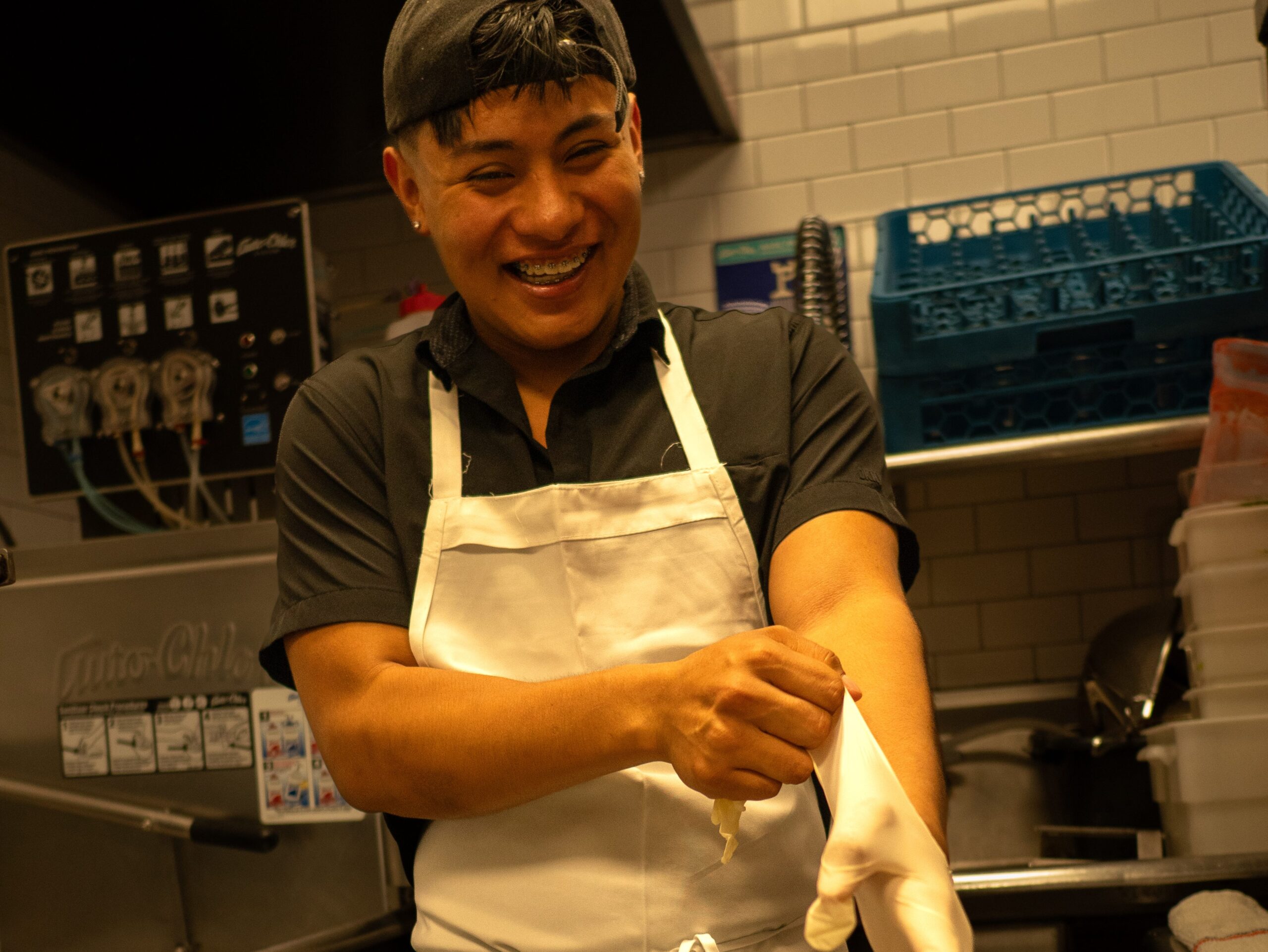 These Nine L.A. Dishwashers Are the Real Heroes of Your Favorite Restaurants 5 a man wearing an apron smiles while putting on dish gloves